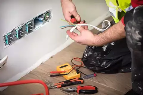 Qualified electrician working on wires in a customer's house in North Dallas